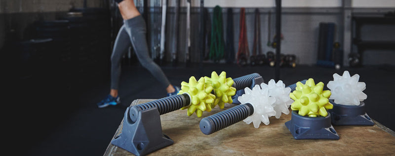 Beastie massage balls and bars laid out on a gym floor